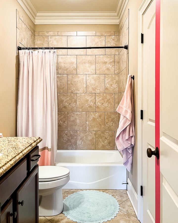 outdated brown shower tiles in girl's bathroom