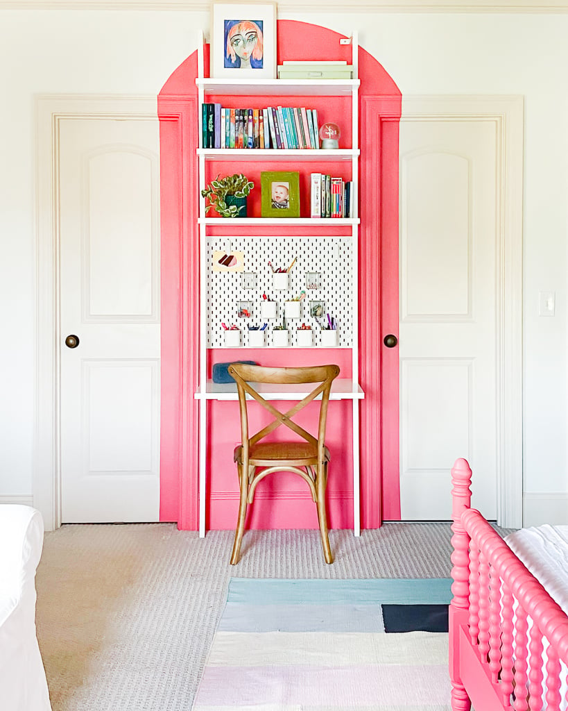 coral arch painted behind wall mounted desk with wood chair