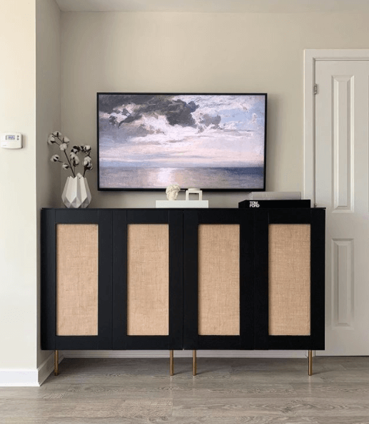 A console table hack from IKEA kitchen cabinets holds storage and a TV on top. 