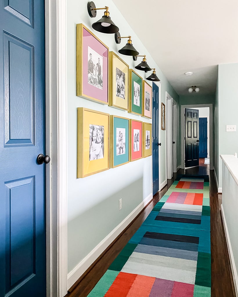 A lovely, colorful hallway with a gallery accent wall and a long, skinny color-blocked West Elm runner.