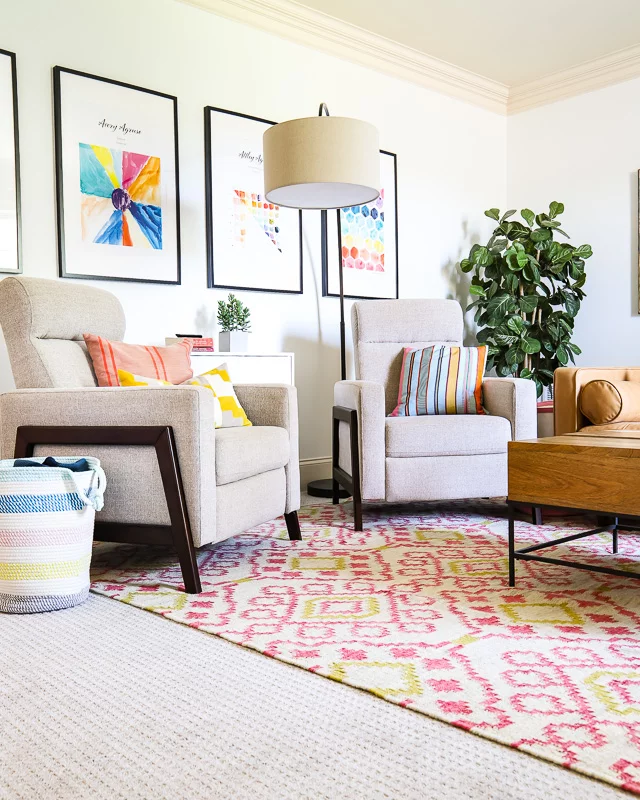 2 accent chairs in colorful family room on pink print rug