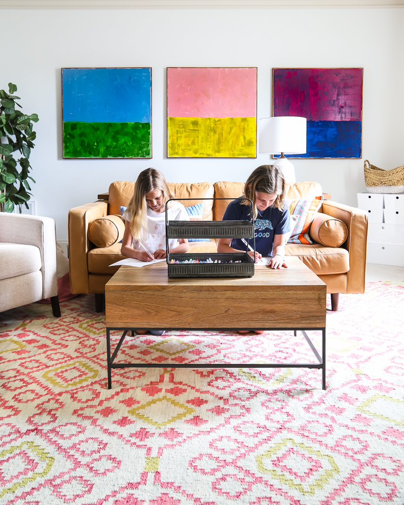 two girls coloring at coffee table in colorful family bonus room