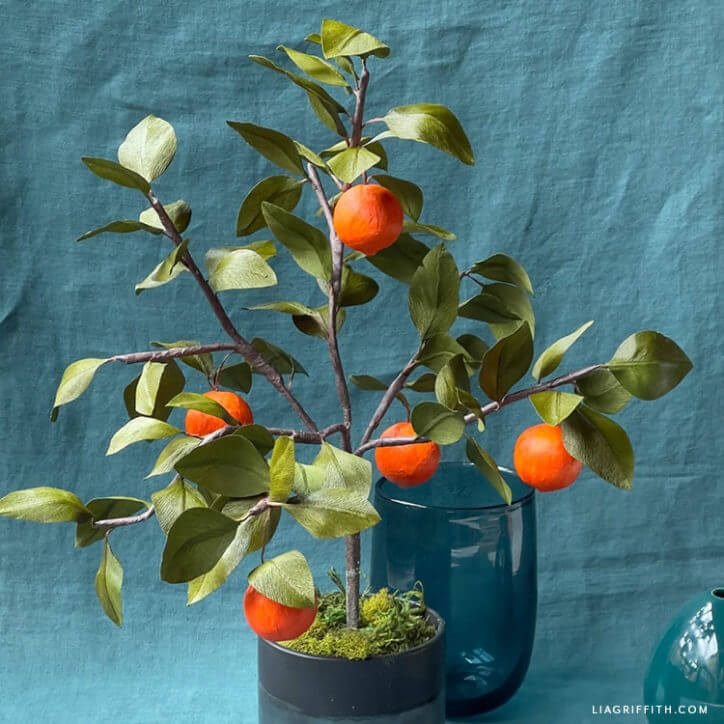 decoupaged crepe paper oranges on a potted tree branch