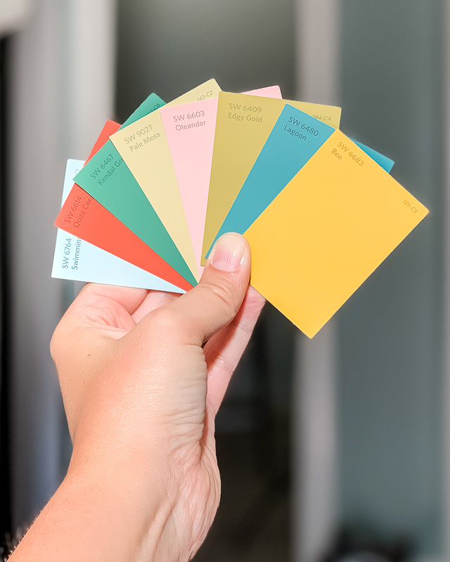how to choose paint colors- woman holding a variety of paint chip samples