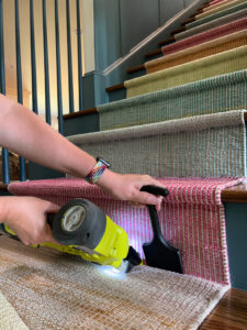 photo of woman installing a DIY stair runner
