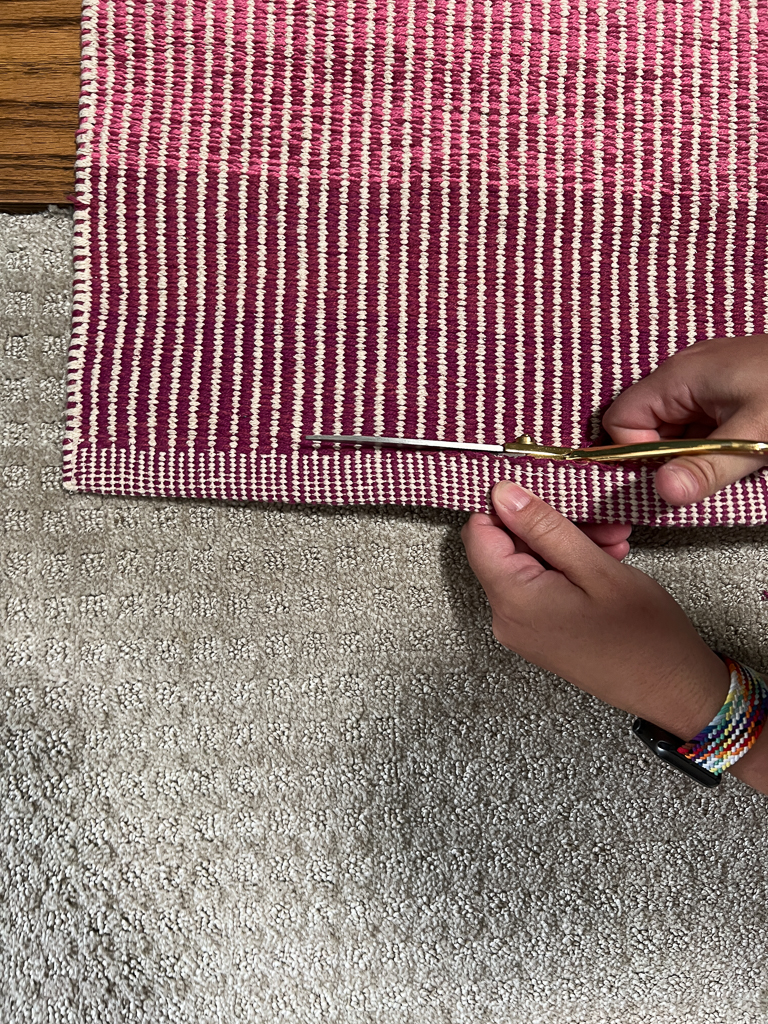 cutting factory edge off of rug with scissors