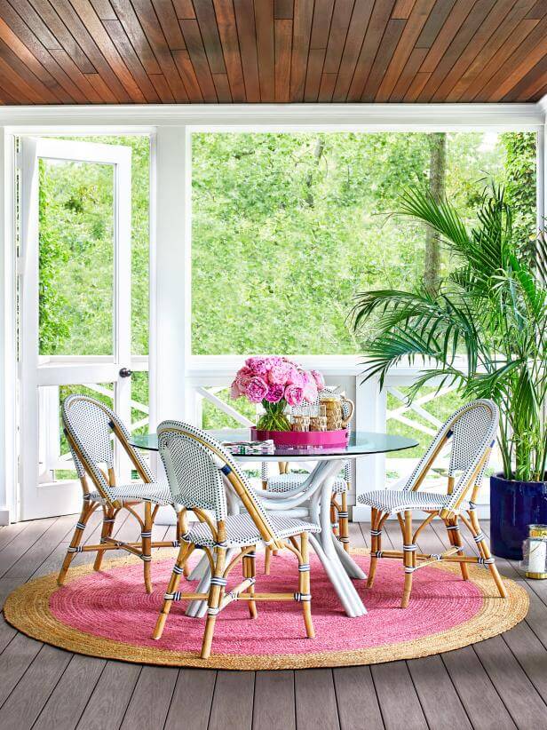 screened-in porch with pink and navy accents and wood plank ceiling