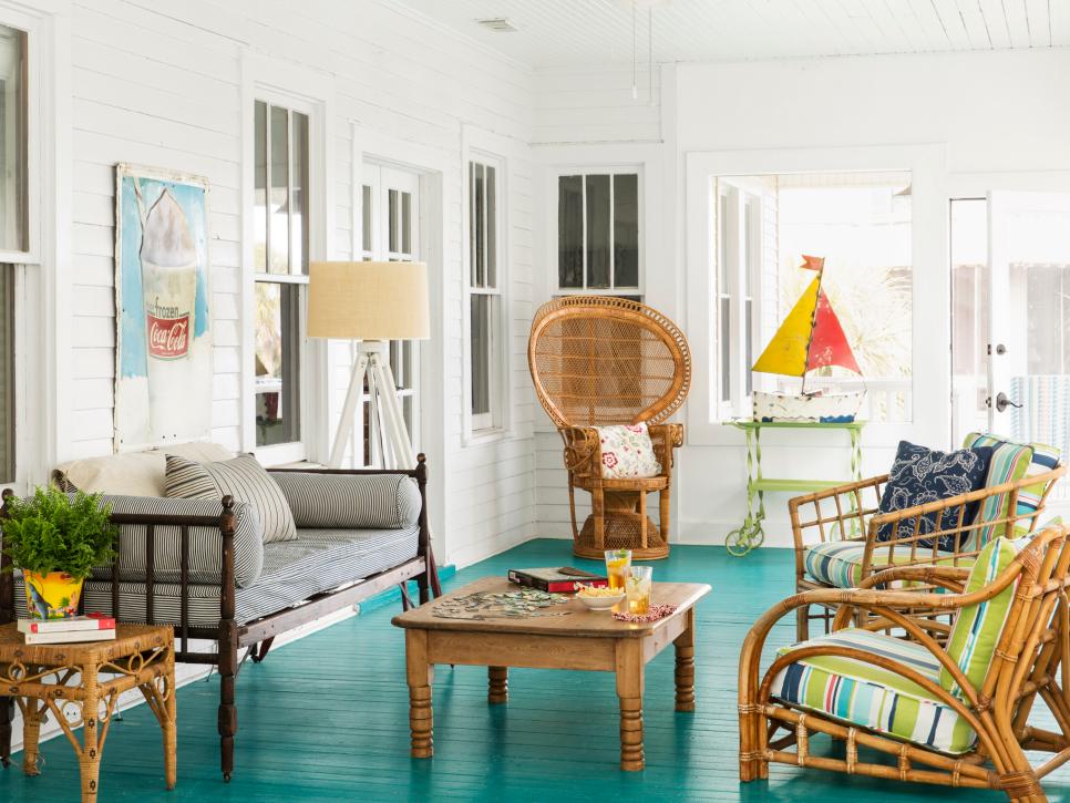 teal painted porch floor with bright decor and wood furniture