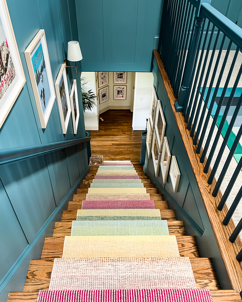 blue staircase with colorful artwork and stair runner