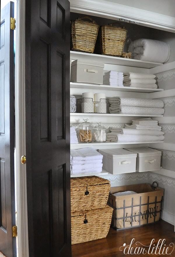 organized linen closet with stenciling and neutral colors