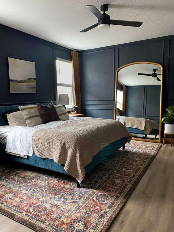 blue gray bedroom with giant gold mirror
