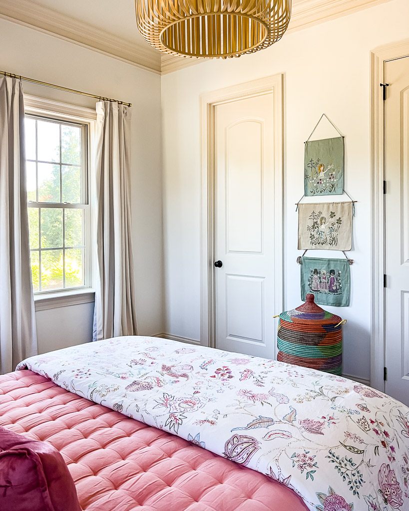 colorful guest room with vintage embroidered art