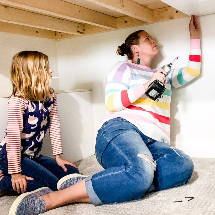 mom and daughter building built-in bunk bed together