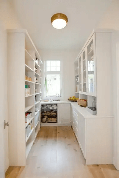 white pantry with window, shelves and cabinetry