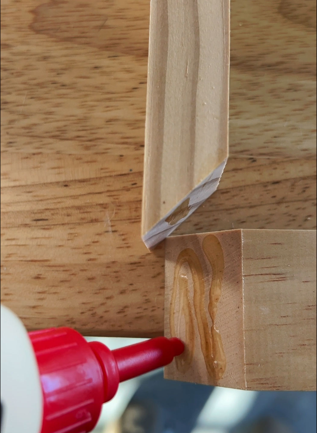 applying DAP Weldwood Instant Adhesive to mitered corners of DIY canvas frame