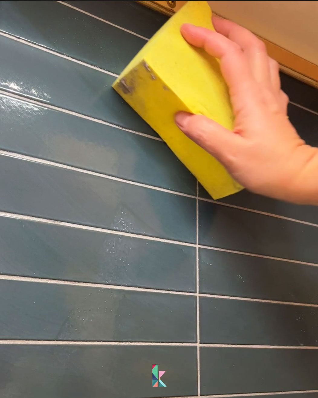 wiping excess grout off of backsplash tile