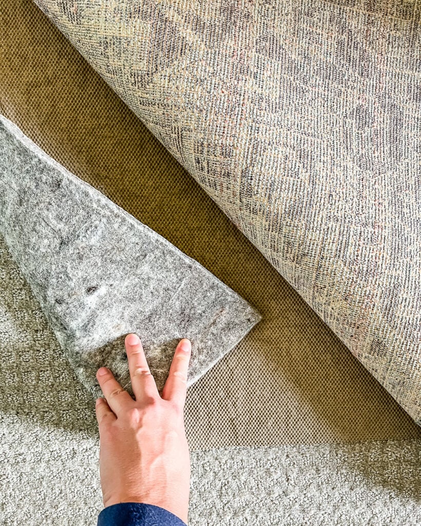 https://designertrapped.com/wp-content/uploads/2023/03/area-rug-over-carpet-rug-pad-2-820x1025.jpg