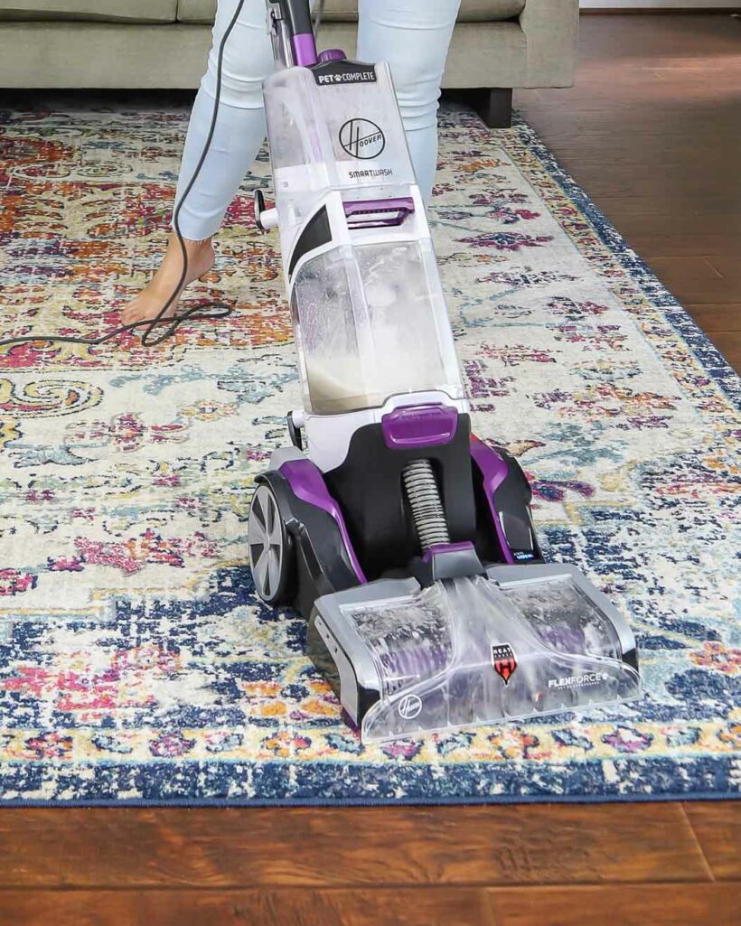woman using Hoover SmartWash Carpet Cleaner on area rug