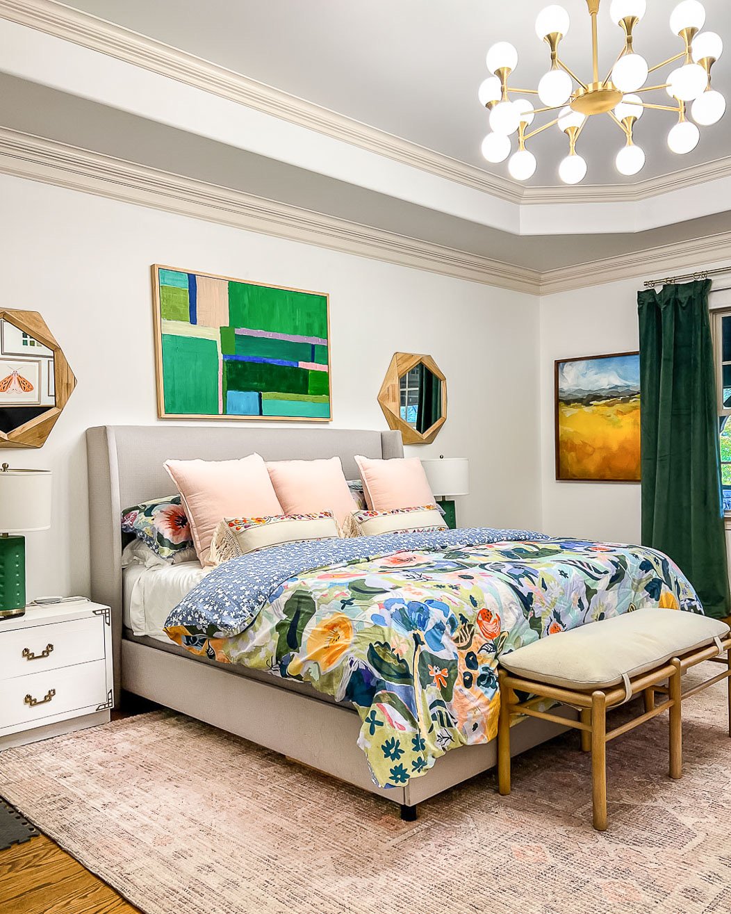 A 9 x 12 West Elm affordable area rug under a king size bed in a colorful and tidy bedroom.