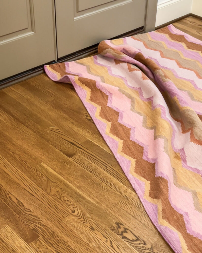 bunched up pink patterned rug in front of door