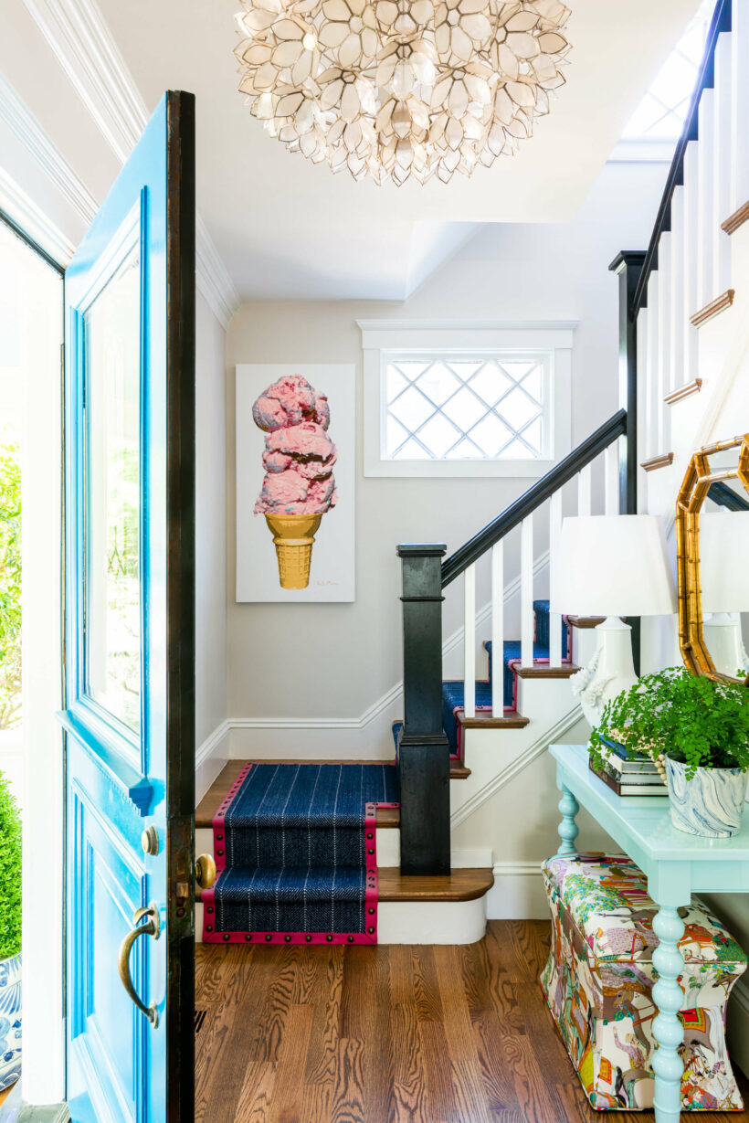 eclectic entryway with black stair railing, blue and pink runner and ice cream art
