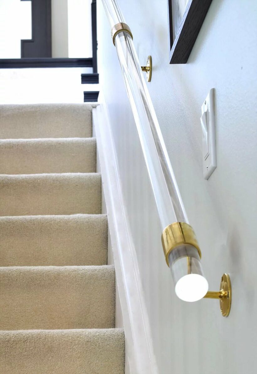 lucite bannister with brass accents in white stairwell