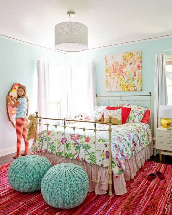 bright floral girl's bedroom with vintage iron bed and bright pink rug