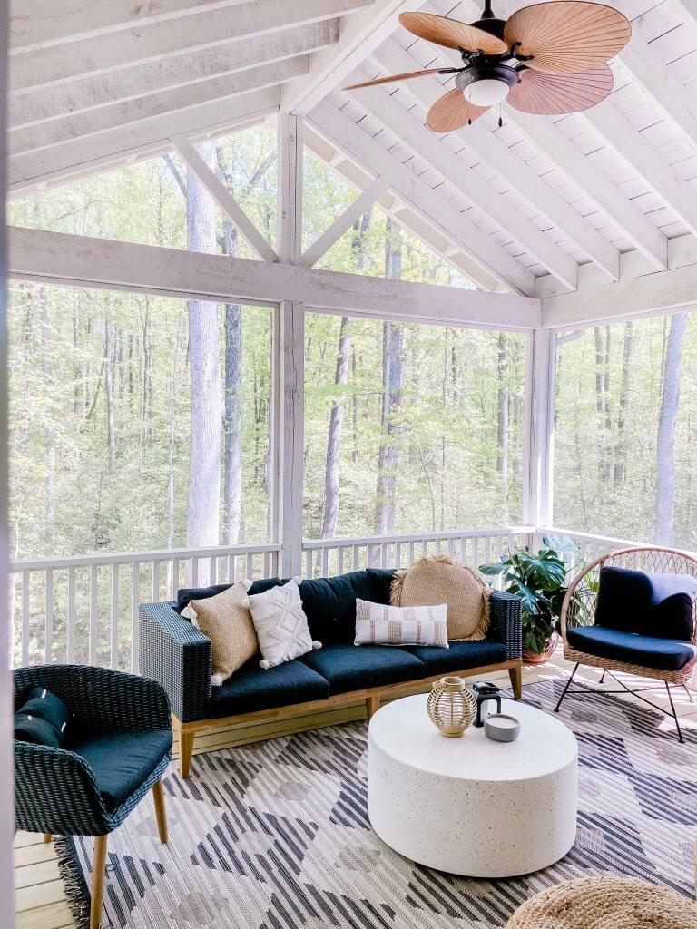 screened-in porch with ceiling fan and black and white decor