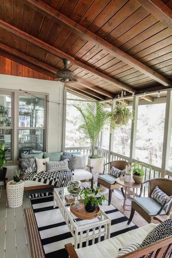 screened in porch with stained ceiling and black and white boho decor