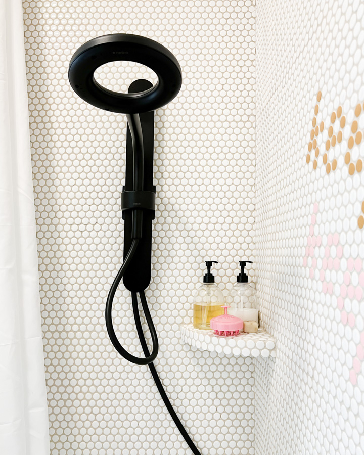 new black shower head in girl's bathroom