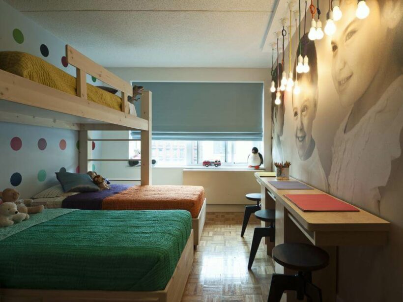 narrow kids' room with double bed bunk bed and desk along wall