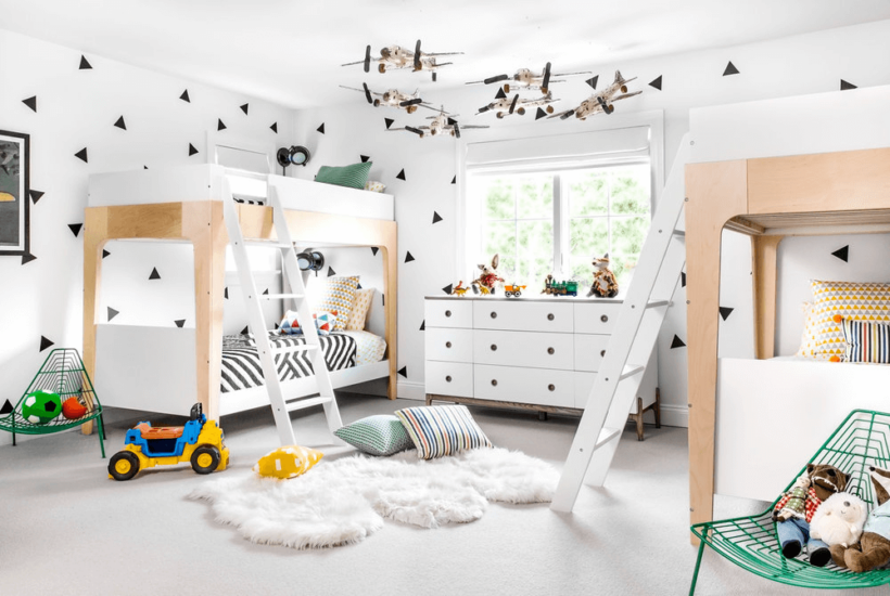 black and white kids room with two set of bunk beds and planes hanging from ceiling