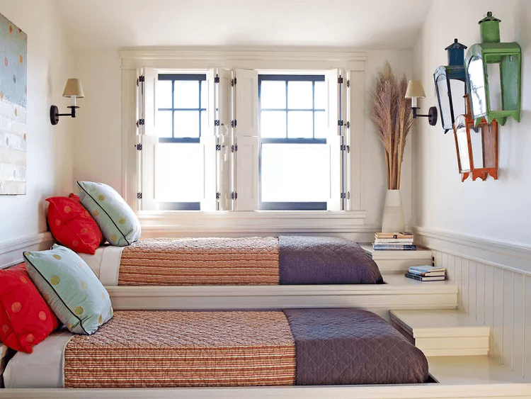 platform beds with striped bed spreads in front of windows