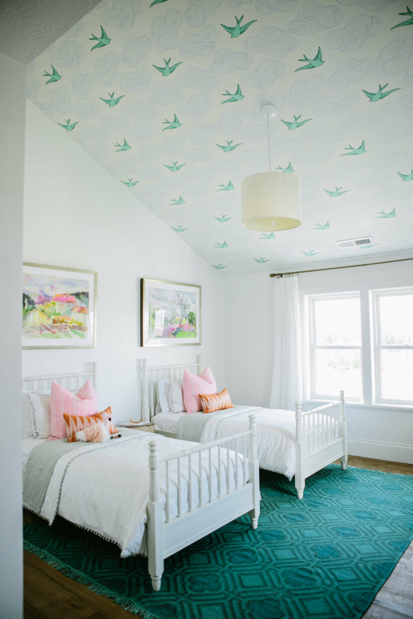 white girls' room with emerald green rug and wallpaper ceiling with clouds and birds