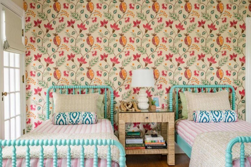 pink and orange floral print wallpaper with turquoise jenny lind beds and striped bedspreads
