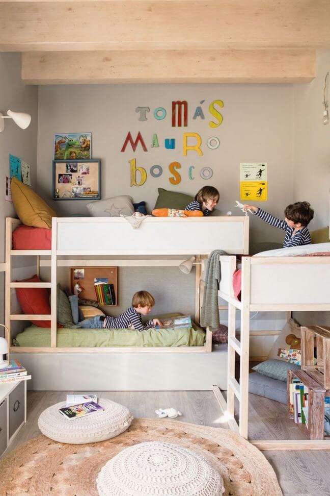 triple bunk bed with kids laying in each bed and primary color decor