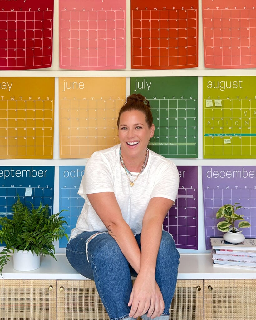 Tasha Agruso of Kaleidoscope Living sitting in front of colorful wall calendar