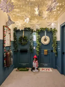 light up paper snowflake lanterns hanging from ceiling in a hallway decorated for Christmas