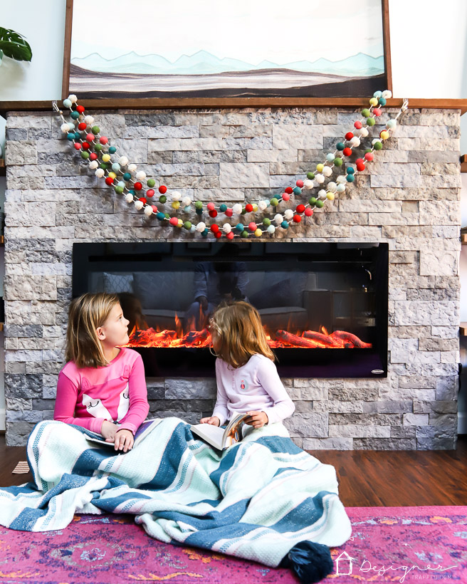 DIY electric fireplace with two girls in front of it