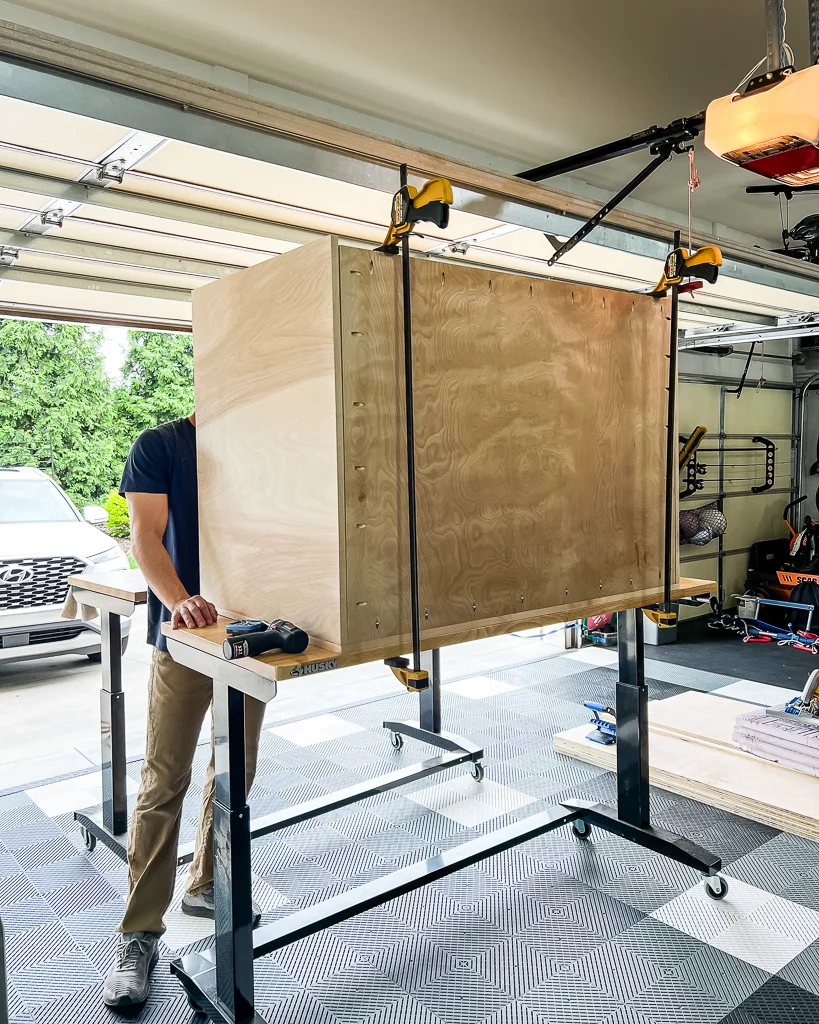 photo of man assembling a DIY dog crate made of plywood