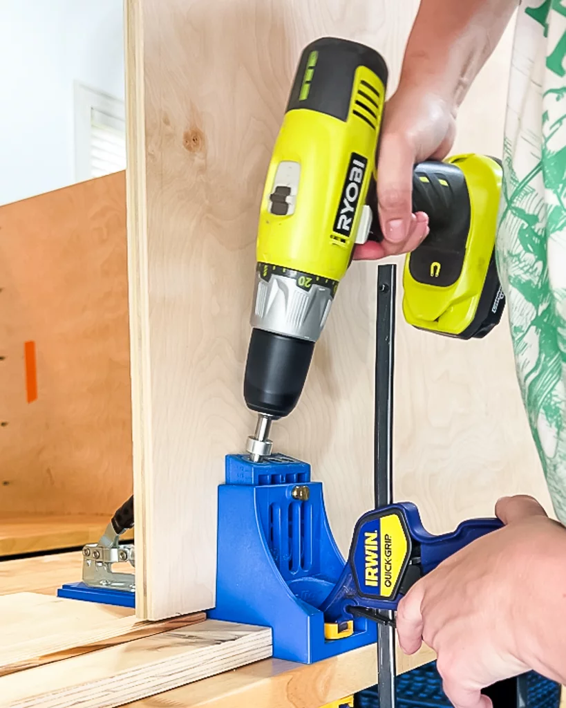 woman's hands drilling pocket holes in plywood using Kreg jig