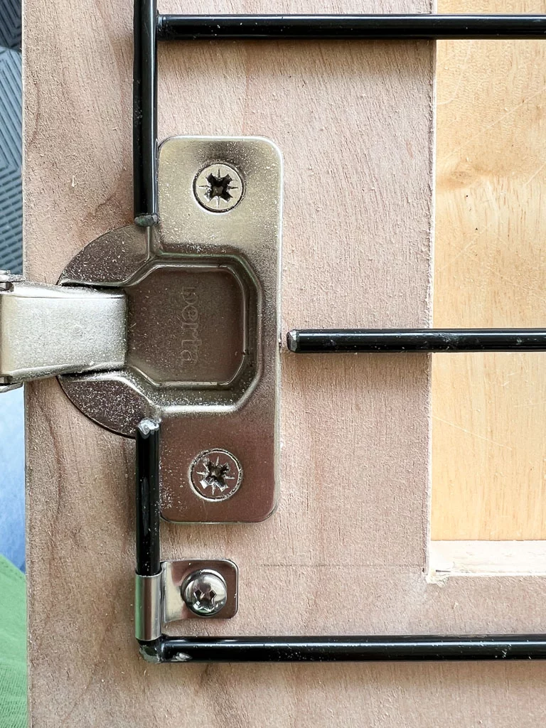 close up photo of concealed door hinge in the door frame of a wooden DIY dog crate