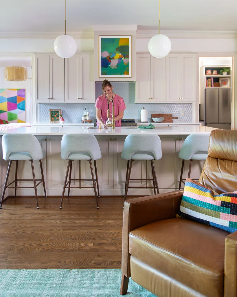 Tasha Agruso of Kaleidoscope Living washing dishes in newly renovated kitchen with kitchen cabinets painted Accessible Beige by Sherwin Williams