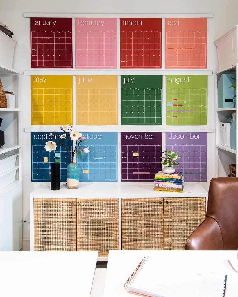 colorful wall calendar hanging in office from faux oversized poster hangers