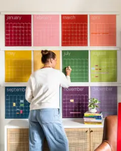 large colorful wall calendar hanging in office with faux poster hanging rails