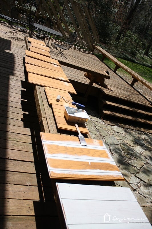 photo of stained oak kitchen cabinet doors in the process of being painted a light gray color